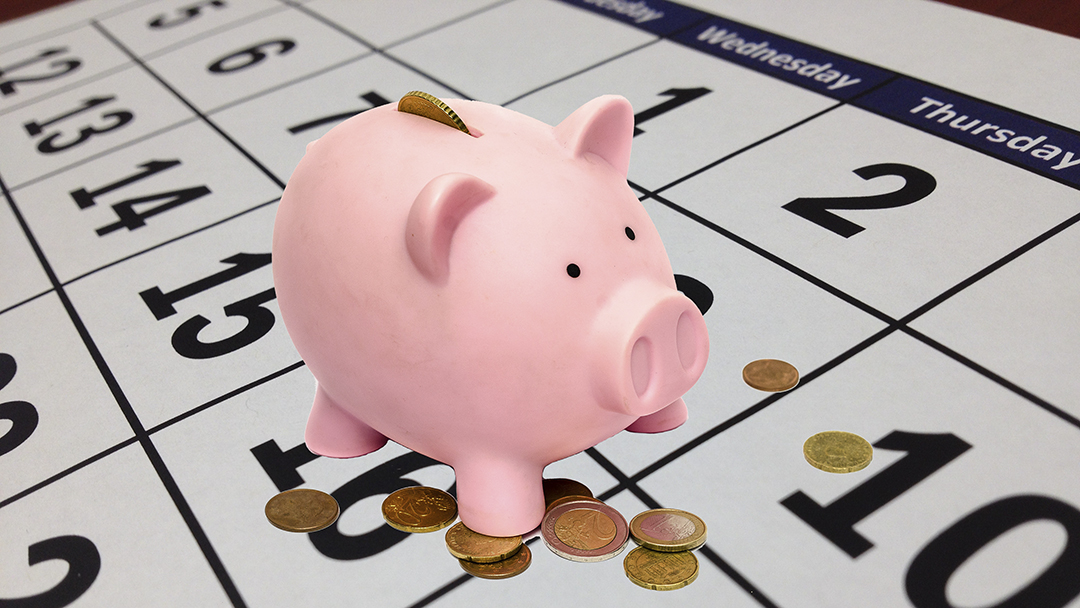 Spaarvarken met muntjes op een kalender - no-spend month